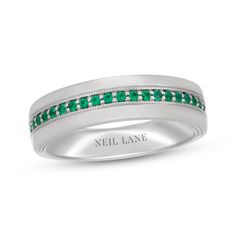 a wedding band with emerald stones in white gold