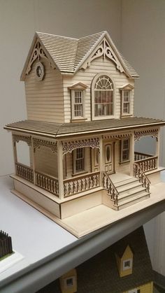 a doll house sitting on top of a table next to a window and door frame