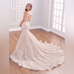 a woman in a wedding dress is standing on the floor with her back to the camera