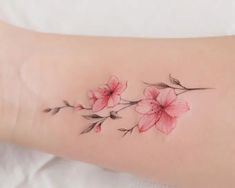 a woman's arm with pink flowers on it