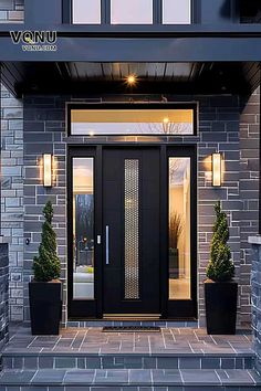 the front door of a modern home with two potted plants