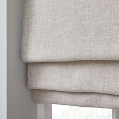 a close up of a roman blind in a window with the blinds pulled back and closed