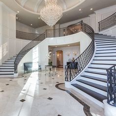 a large foyer with stairs and chandelier