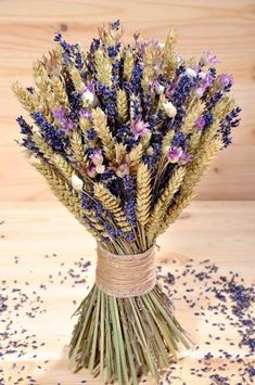 a bunch of dried flowers sitting on top of a wooden table next to confetti sprinkles