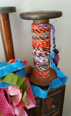 a wooden chair next to a pile of colorful ribbons on top of a dresser with a hammer in the background