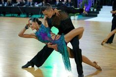 two people dancing on a dance floor in front of an audience