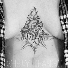 a woman's chest with a heart and flowers tattoo on her back, in black and white