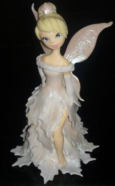 a white fairy figurine sitting on top of a table