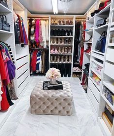 a walk - in closet with white shelves and chandelier hanging from the ceiling