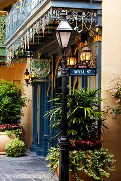 a lamp post in front of a building with lots of plants and lights on it