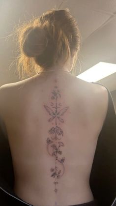 the back of a woman's body with tattoos on her upper and lower back