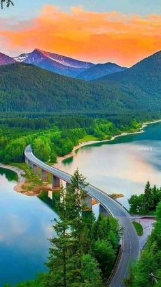 an aerial view of a bridge over a body of water with mountains in the background