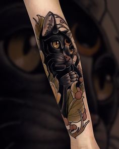 a black cat tattoo on the left forearm and right arm, with flowers around it