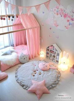 a bedroom with pink and white decor on the walls, bedding and decorations around it