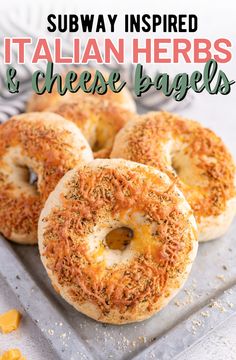 three bagels with cheese and herbs on top are sitting on a metal platter