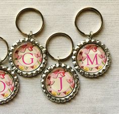 four personalized bottle openers with flowers and the initial letter j on each one