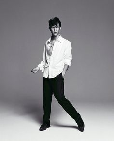 a young man in white shirt and black pants posing for a magazine cover shot with his hand on his hip