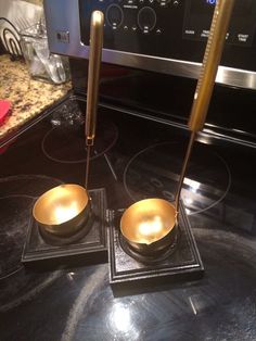 two golden singing bowls sit on top of black granite counter tops in front of an oven