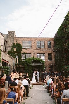 a couple getting married in front of an old brick building