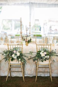 the table is set up with gold chairs and floral centerpieces