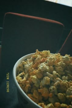 a white bowl filled with popcorn sitting on top of a table