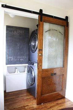 a washer and dryer sitting in front of a chalkboard on the wall