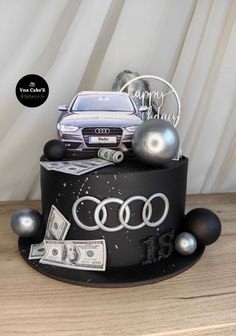 a car is on top of a cake with money and balloons in the shape of balls