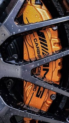 the front wheel of a motorcycle with water droplets on it's tires and brake pads