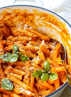 a bowl filled with pasta and sauce covered in parmesan cheese