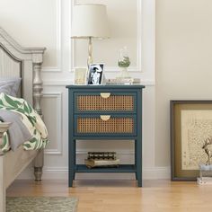 a bedroom with a bed, night stand and pictures on the wall next to it