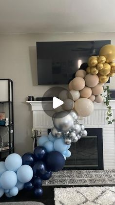 a living room filled with balloons and a tv mounted to the wall next to a fire place