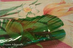 a green vase sitting on top of a table next to a flowered wallpaper