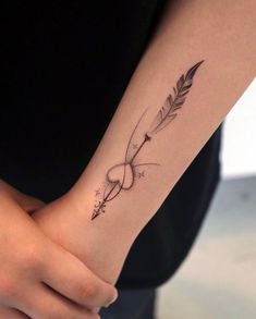 a woman's arm with an arrow tattoo on it