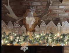 a fireplace mantle decorated with christmas decorations and deer heads