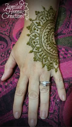 a woman's hand with henna tattoos on it