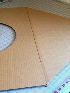 an open cardboard box sitting on top of a cutting mat