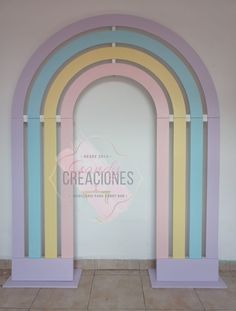 a large arch is painted in pastel colors and stands against a white wall with tile flooring