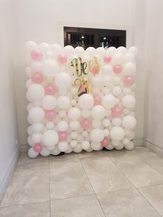 the balloon wall is decorated with pink and white balloons