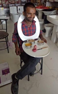 a man sitting in a chair holding a plate with food on it