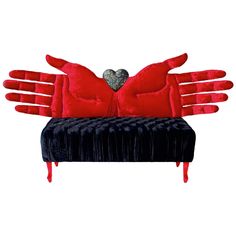 a red heart shaped pillow sitting on top of a black bench with arms and legs