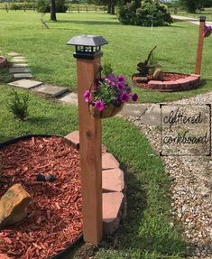 a wooden post with purple flowers in it and a mailbox on the other side