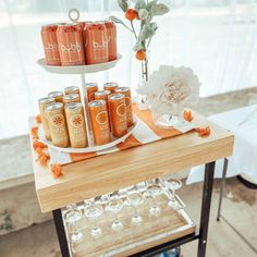 a table topped with jars filled with liquid and flowers on top of a wooden tray