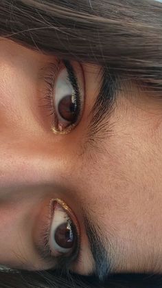 a close up of a person's eyes with brown and white contactions on them