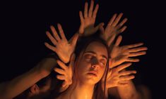 a woman is surrounded by her hands in the air