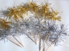 there are several sticks with gold and silver decorations on top of each other in the shape of stars