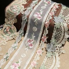 several pieces of fabric with flowers and lace on them