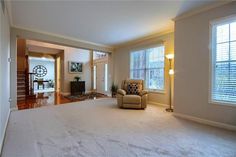 an empty living room with white carpet and furniture