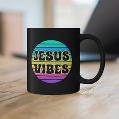 a black coffee mug with the words jesus vibes on it sitting on a wooden table