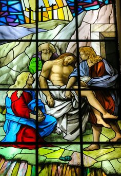 a stained glass window depicting the birth of jesus and mary, with two men kneeling down