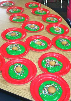 paper plates with donuts and sprinkles on them sitting on a table